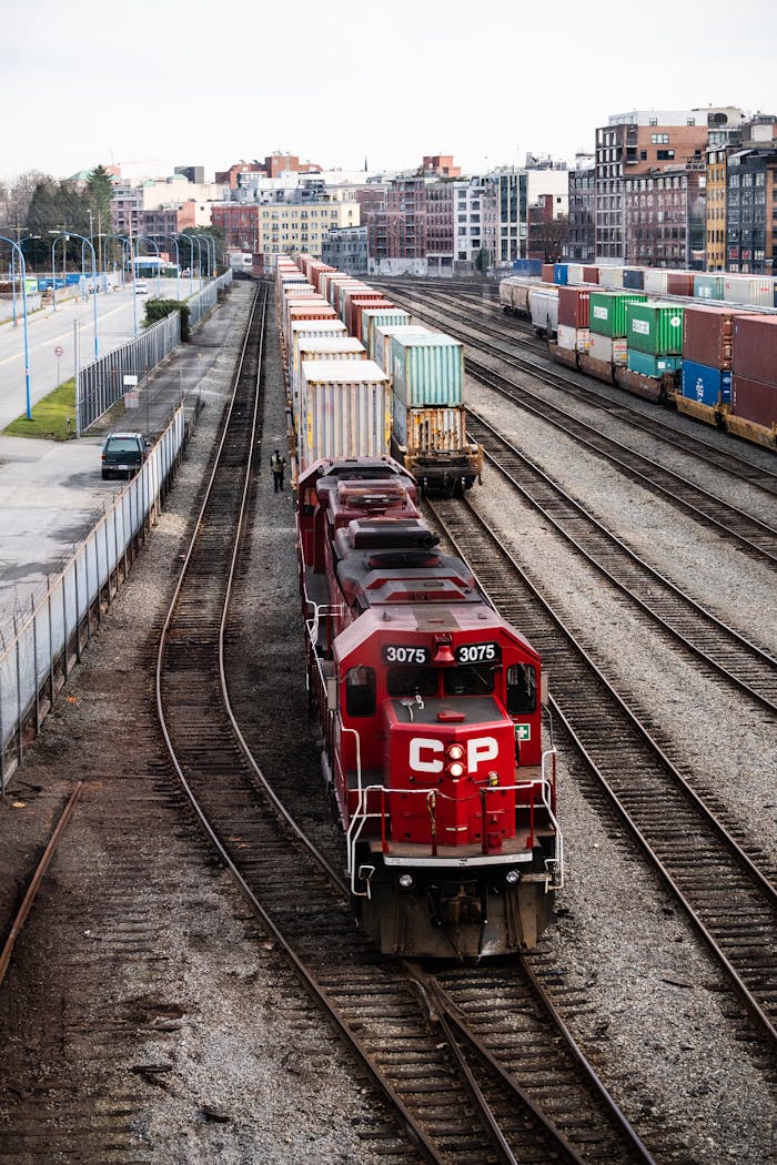 The Art of Drawing Readers In: Your attractive post title goes here A red freight train with containers at a rail yard in Vancouver, showcasing industrial transportation.